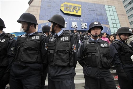 Security guard personnel stand guard as many people line up outside one of the Shanghai outlets Best Buy closed earlier this week to complain or seek help with customer service on Friday in Shanghai, China.
